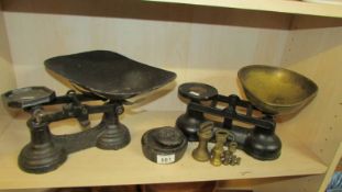 Two sets of kitchen scales and a quantity of weights.
