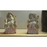 A pair of continental bisque porcelain seated figures.