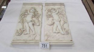 A pair of cherub wall plaques.