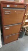 A three drawer filing cabinet with key.