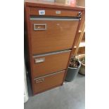 A three drawer filing cabinet with key.