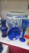 A blue glass vase, blue glass bowl and blue glass candleholder.