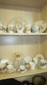 Two shelves of vintage royal commemorative china.