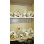 Two shelves of vintage royal commemorative china.