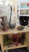 Two shelves of art glass, drinking glasses etc., including cranberry.