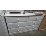 A white six drawer chest.