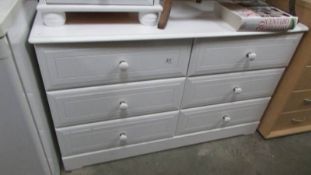 A white six drawer chest.