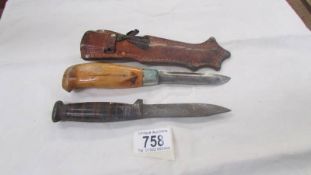 A hunting knife in sheath and one other.