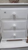 A white three drawer bedroom chest.