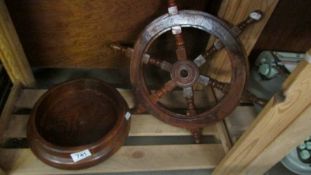 A wooden ship's wheel and a wooden bowl.