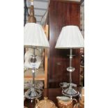 A pair of chrome and glass bedside lamps with shades.