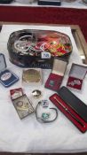 A mixed lot of costume jewellery, compact, badges etc.