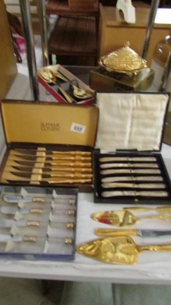 A quantity of cased cutlery sets and a boxed oyster shell butter dish.