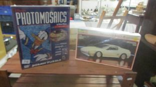 A Revell A/24 Nissan model kit and a Disney Donald photomosaic, both unopened.