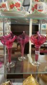 Three cranberry glass 'Jack in the Pulpit' vases.