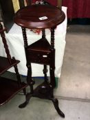 A mahogany tripod plant stand with drawers