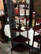 A dark wood stained corner whatnot display shelf unit