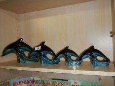 A set of 4 graduated Poole pottery dolphins