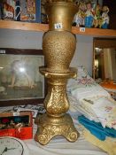 A large gilded vase on a pedestal.