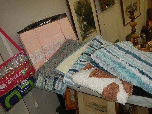 A quantity of new bath mats and towels.