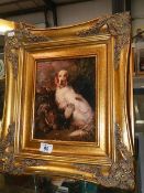 An antique style gilded framed print of a retriever with game bird