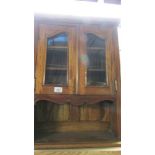 A reproduction mahogany wall unit cabinet with bevel glass doors