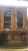 A reproduction mahogany wall unit cabinet with bevel glass doors