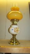 A ceramic and glass oil lamp with brass effect base,