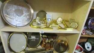 Two shelves of miscellaneous metal ware including picture frames, brass industrial door handles,