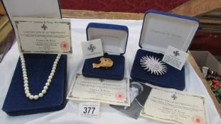 Three pieces of Camrose & Ross "Jackie Kennedy" jewellery being a pearl necklace and two brooches.