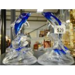 Two glass dolphins.