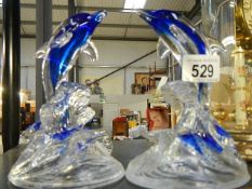 Two glass dolphins.