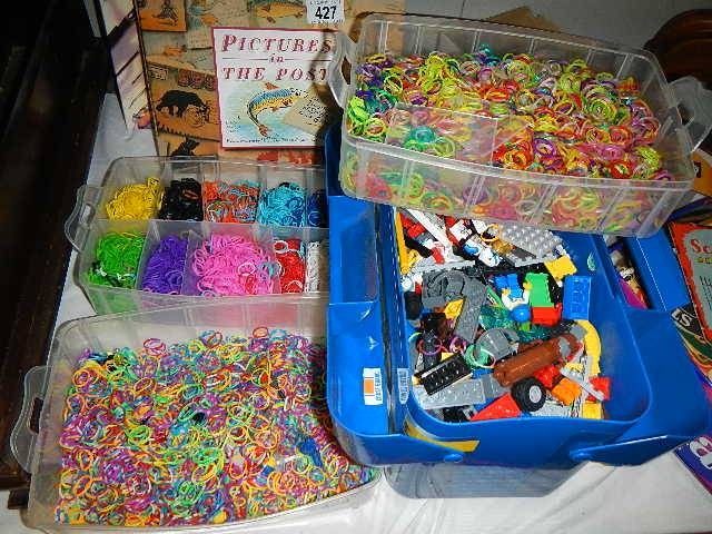 A box of Lego and two boxes of brightly coloured rubber bands.