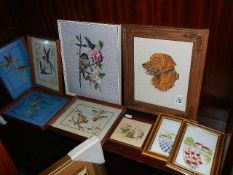 A quantity of framed and glazed cross stitch pictures.