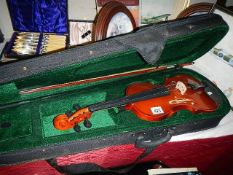 A cased violin with bow.