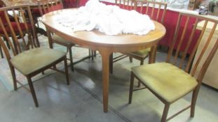 An oval teak dining table with five chairs. (Collect only)