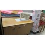 A sewing machine in cabinet. (Collect only)