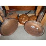 Two copper warming pans, two copper moulds and a copper kettle.