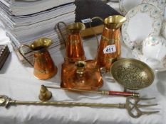 A set of three graduated copper jugs, brass toasting fork etc.,