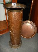 A copper umbrella stand and a copper warming pan.