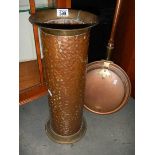 A copper umbrella stand and a copper warming pan.