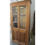 A pine cabinet with glazed doors. (Collect only)