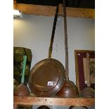 A copper warming pan and three copper washing dollies. (Collect only)