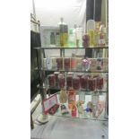 Four shelves of assorted toiletries, perfumes etc.,