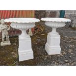 Matching Pair of bulbous shaped Cast Iron Garden Urns, fixed onto tall and square bottom plinths,