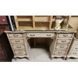 A French style painted & parcel gilded kneehole Dressing Table with a mirrored glass top, 123cm