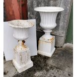 Two Cast Iron Garden Urns on Stands, traditionally ribbed designs, both on cast iron bases, 1) 96cmH