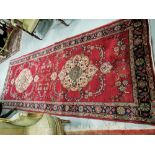 Very large Iranian Runner, with a traditional floral medallion design, red ground, 3.7m x 1.4m