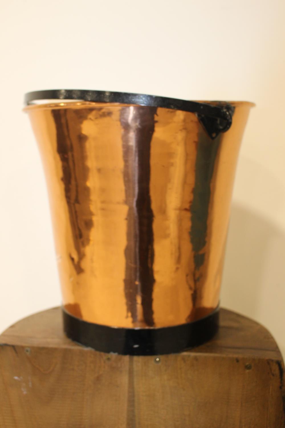 Copper coal bucket with metal handle.