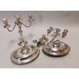 Two silverplate candelabras and two entrée dishes.